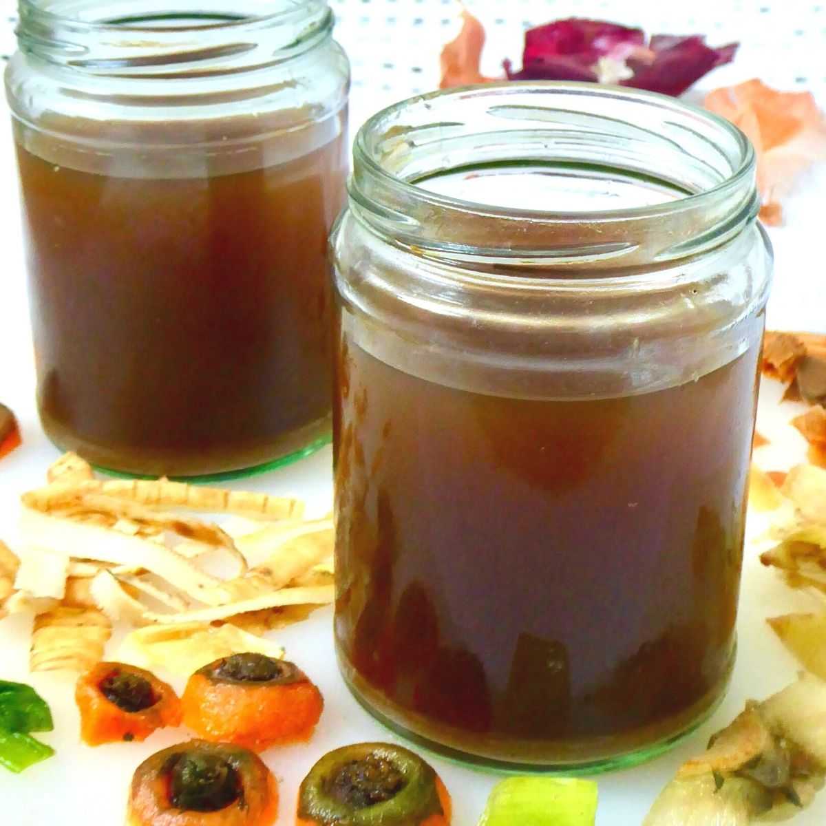 broth stored in glass jars surrounded by vegetable scraps