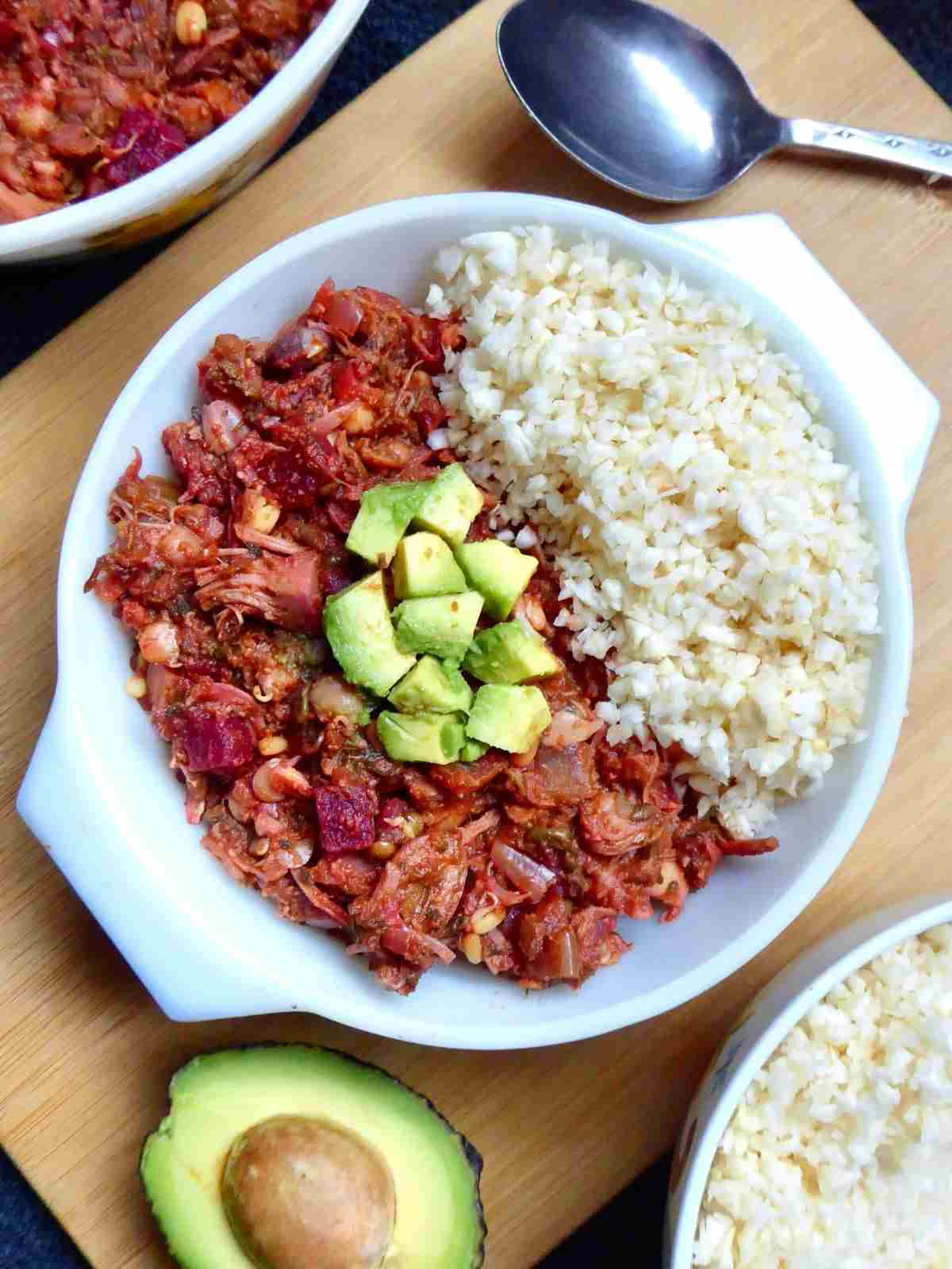 chilli con carne topped with diced avocado and a side dish of celeriac rice